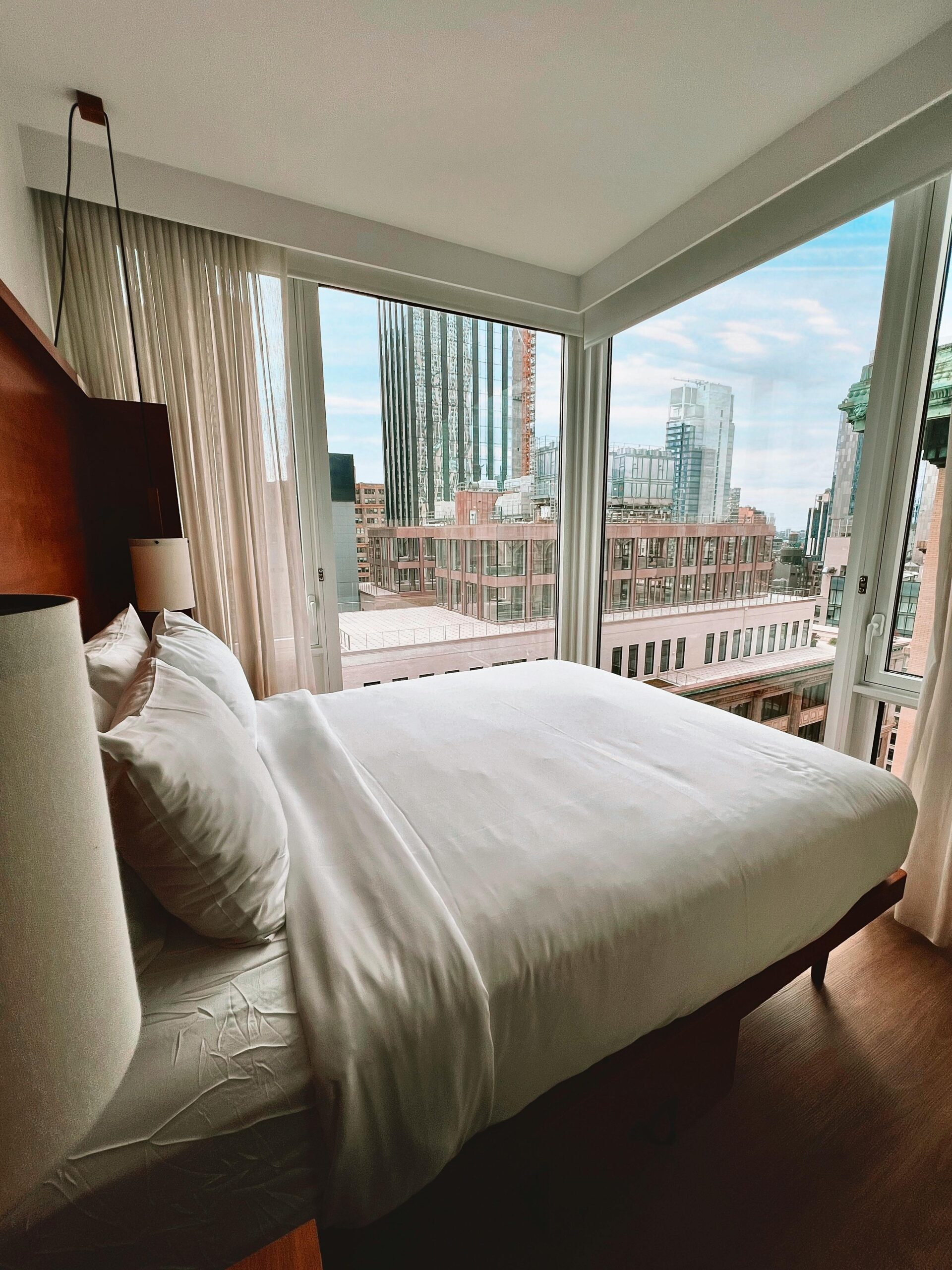 Home Contemporary hotel room overlooking an urban skyline through large windows.