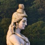 Ultimate Budget Travel Guide for Beginners: 10 Amazing Days in Rishikesh A serene statue of Lord Shiva surrounded by lush greenery in Rishikesh, India.