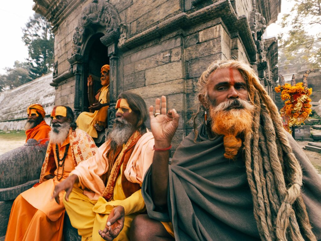 Varanasi Travel Guide: Where Life, Death, and Spirituality Meet Hindu sadhus with traditional attire and dreadlocks sitting outside a temple.
