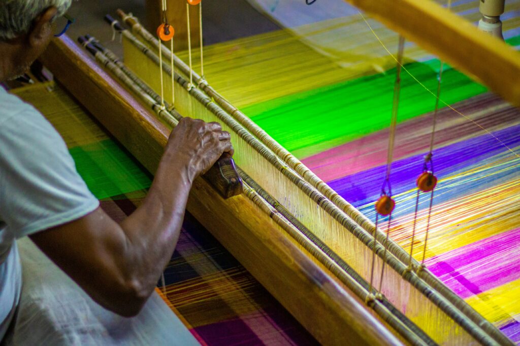 Varanasi Travel Guide: Where Life, Death, and Spirituality Meet A skilled artisan weaving vibrant silk threads on a traditional loom, showcasing creativity and craftsmanship.
