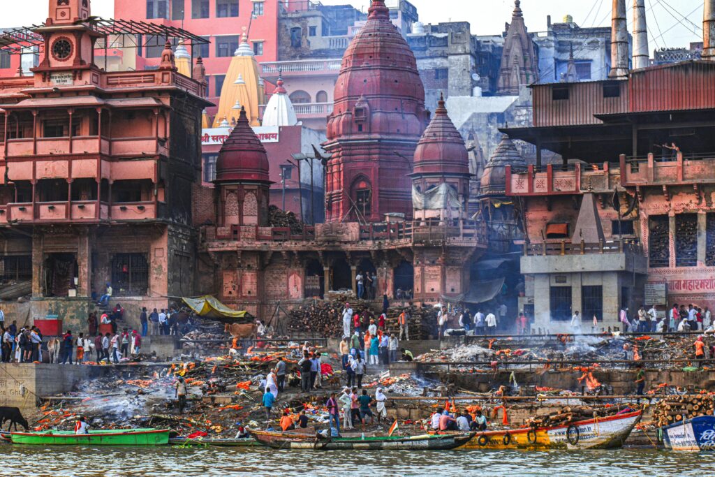 Varanasi Travel Guide: Where Life, Death, and Spirituality Meet A vibrant scene of rituals at Manikarnika Ghat in Varanasi, showcasing traditional Hindu customs along the Ganges River.