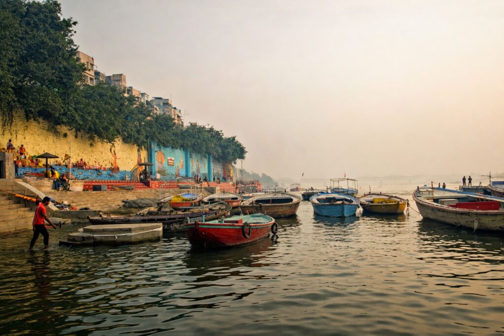 Varanasi Travel Guide: Where Life, Death, and Spirituality Meet Vibrant boats moored on the Ganges River with Varanasi ghats in the background at dawn.