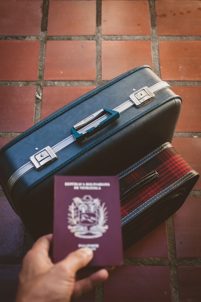 First International Trip Checklist: Everything You Need Before You Fly A traveler's essentials including a passport and suitcase on a red tiled floor, suggesting a journey ahead.