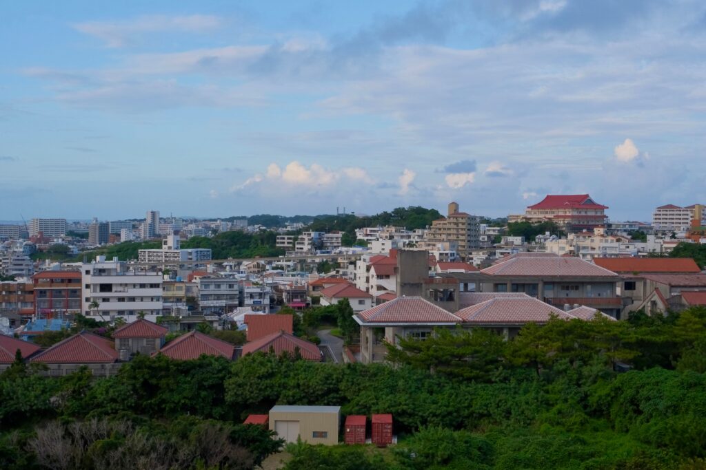 Best Places to Visit in Japan in 2026: 25 Amazing Must-See Gems Panoramic view of Okinawa cityscape with traditional and modern buildings.