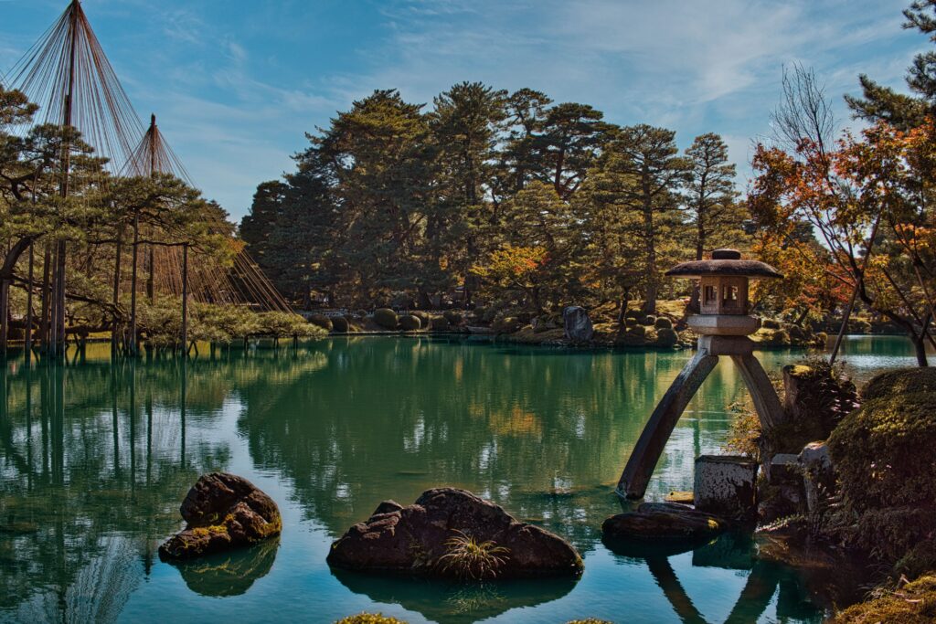 Best Places to Visit in Japan in 2026: 25 Amazing Must-See Gems Serene landscape of Kenrokuen Garden with traditional lantern and tranquil pond in Kanazawa, Japan.
