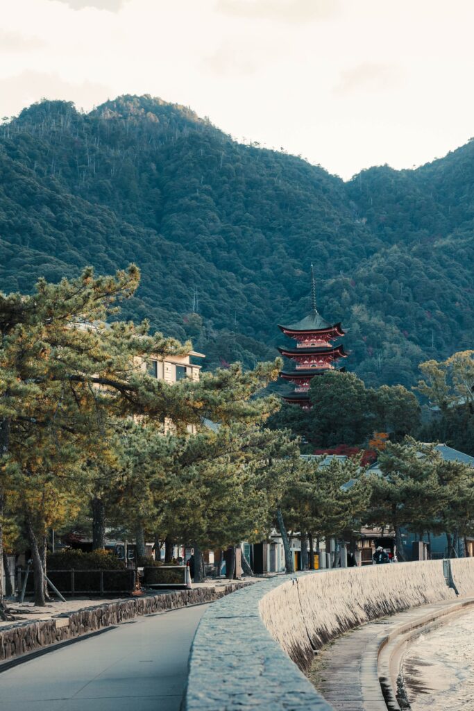 Best Places to Visit in Japan in 2026: 25 Amazing Must-See Gems Serene landscape of a Japanese pagoda by forested mountains in Miyajima, Japan.