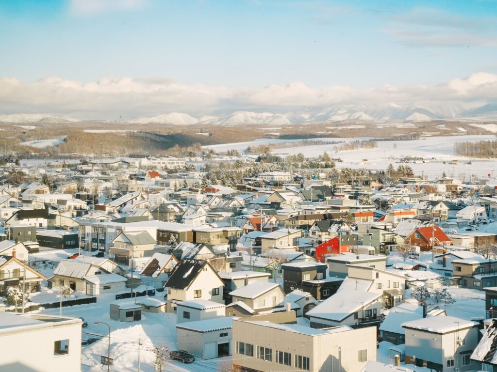 Best Places to Visit in Japan in 2026: 25 Amazing Must-See Gems Aerial view of a snow-covered village in Hokkaido, Japan, showcasing scenic winter landscapes.