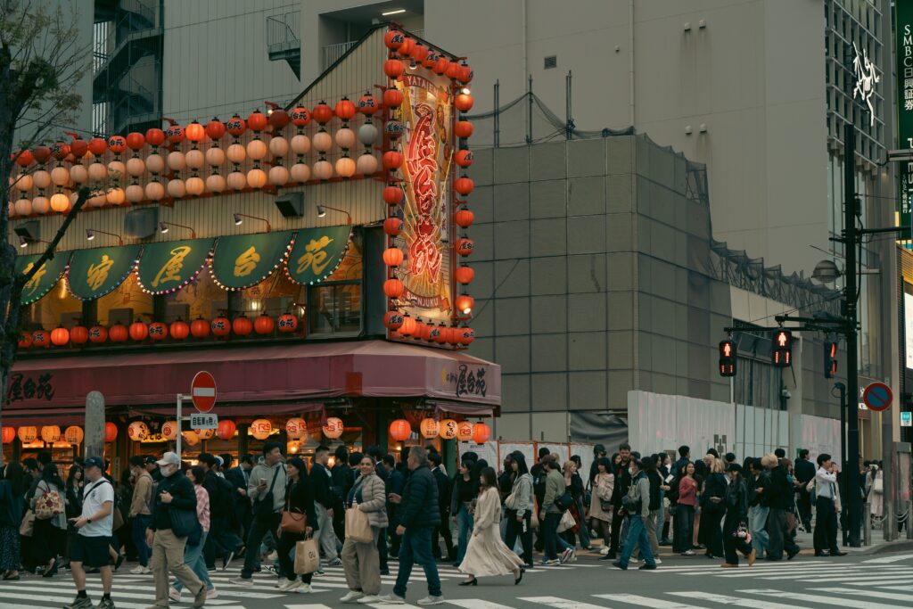 Best Places to Visit in Japan in 2026: 25 Amazing Must-See Gems A lively street in Tokyo's Shinjuku with illuminated signs and crowds crossing.