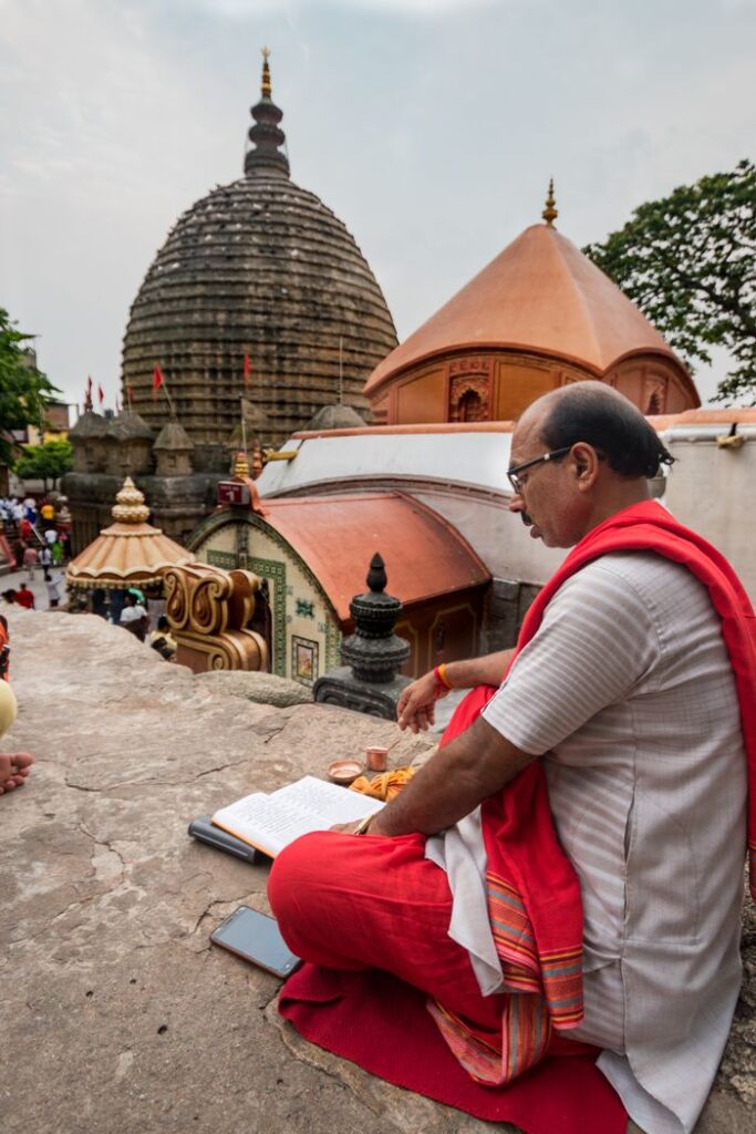 Sacred Places Every Hindu Should Visit – Ultimate Divine Guide A Hindu priest reading scriptures at the Kamakhya Temple in Guwahati, Assam, India.