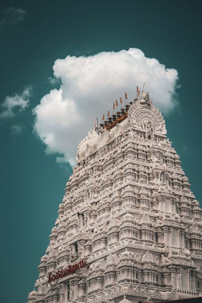 Sacred Places Every Hindu Should Visit – Ultimate Divine Guide Intricate architecture of a Gopuram in India under a dramatic sky, showcasing cultural heritage.